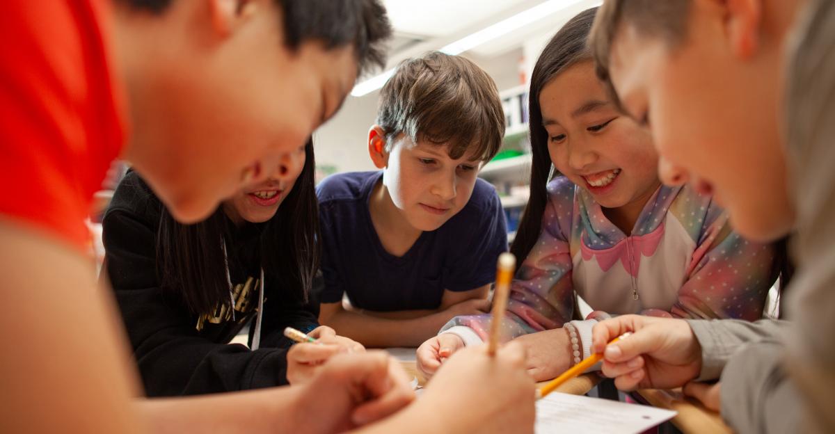 Group of multiracial middle school students talk and enjoy studying together in a classroom