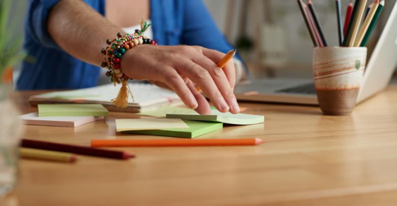 Young teacher using sticky notes when preparing for classes