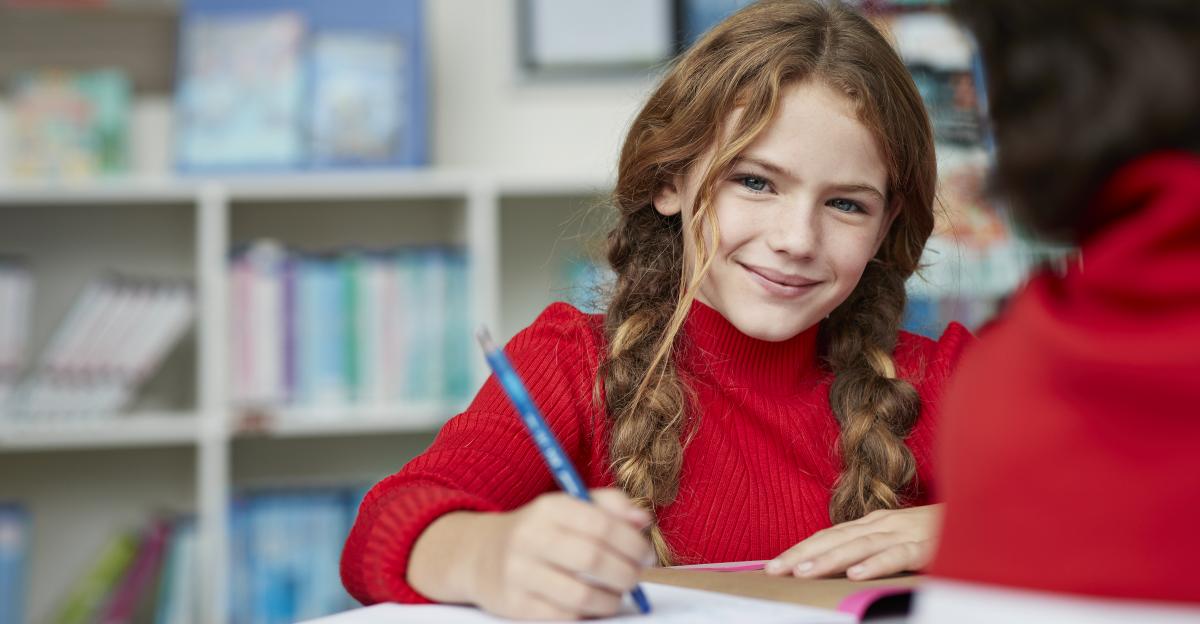 Portrait of cute schoolgirl drawing at the library