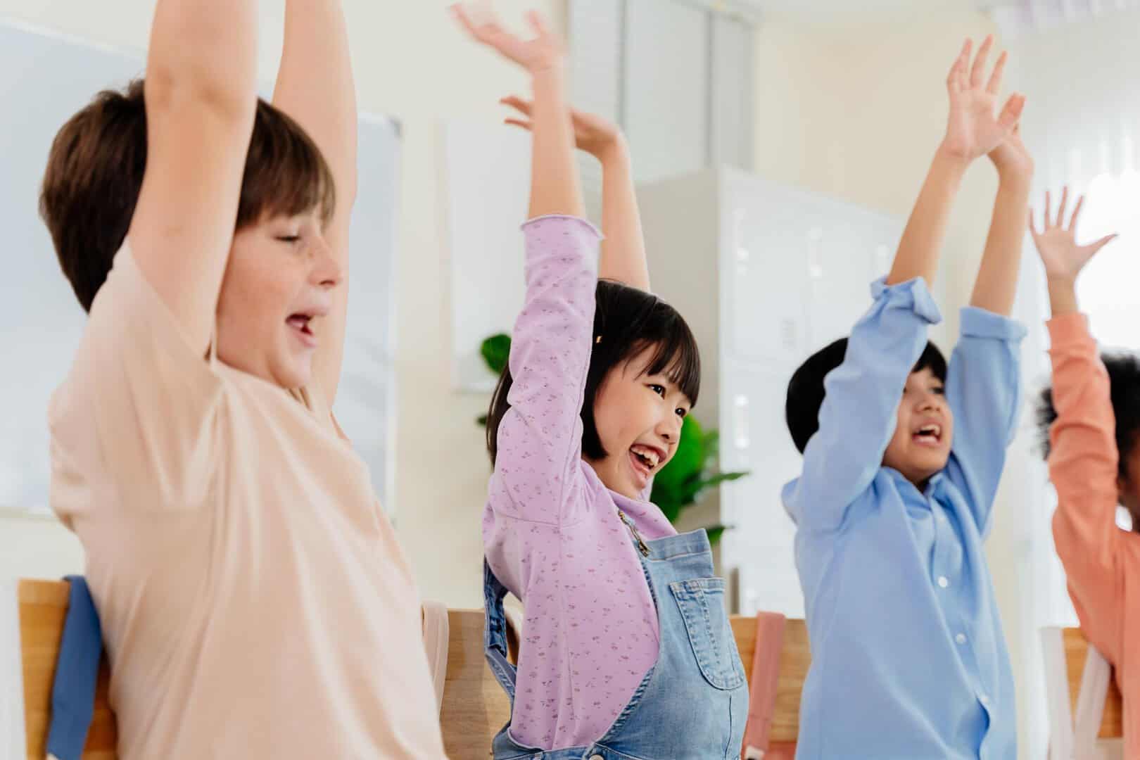 Excited primary school kids from various backgrounds express happiness together. Cheerful classroom scene captures essence of modern education, highlighting unity and active participation