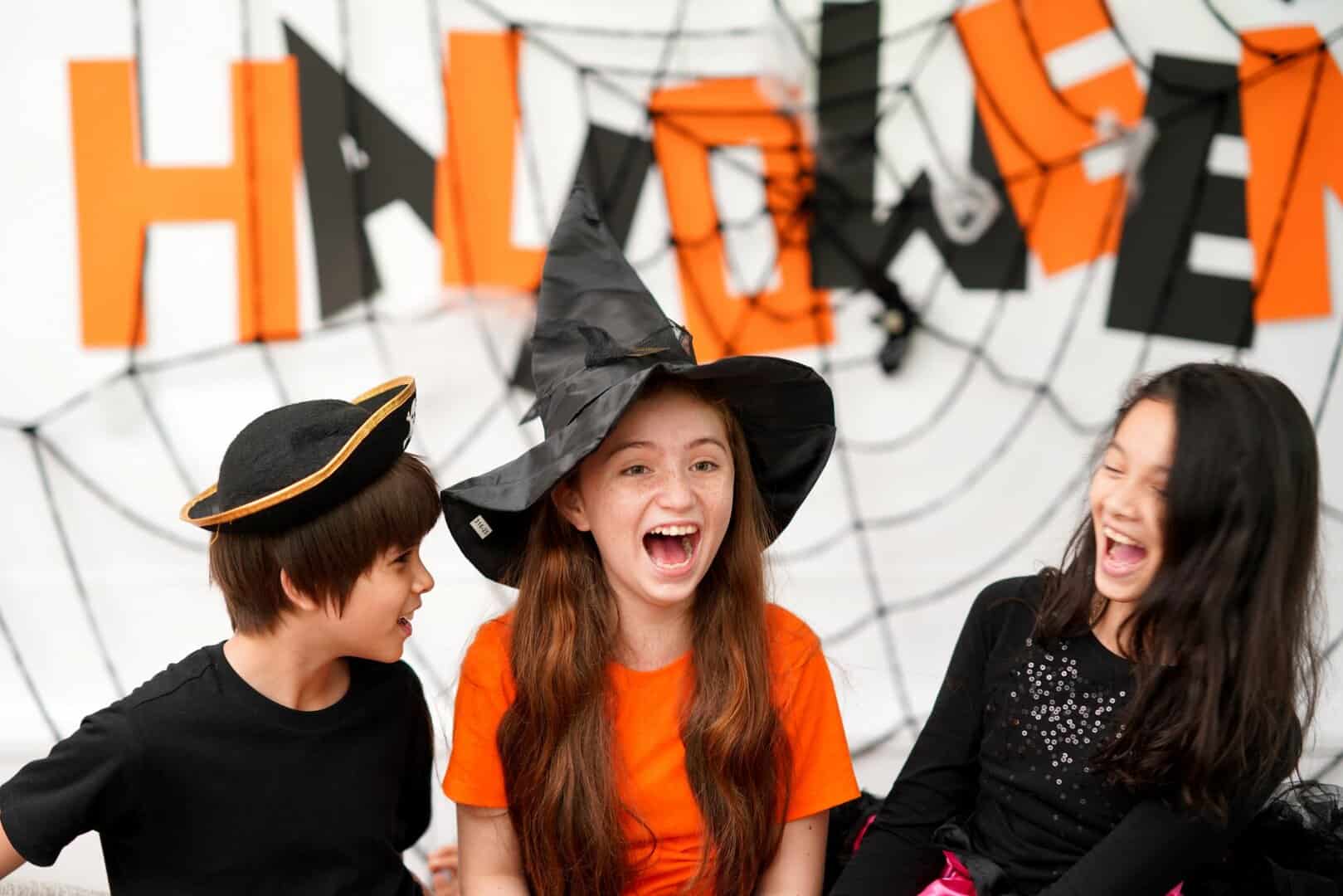 Kids laughing have fun to play games in Halloween celebration party at home