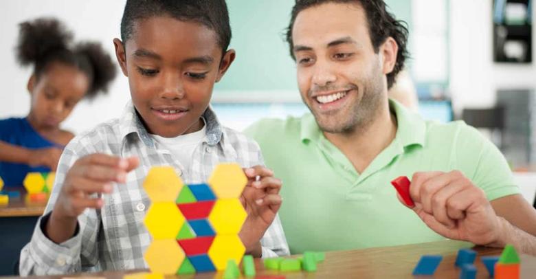 young student and teacher using math manipulatives in classroom