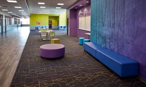 eugene kranz junior high school hallway with benches and tables, bold purple, blue, and yellow colors of walls and furniture