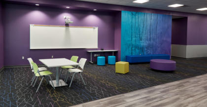 common area at kranz junior high school with bold colors, a whiteboard, and collaboration tables for students
