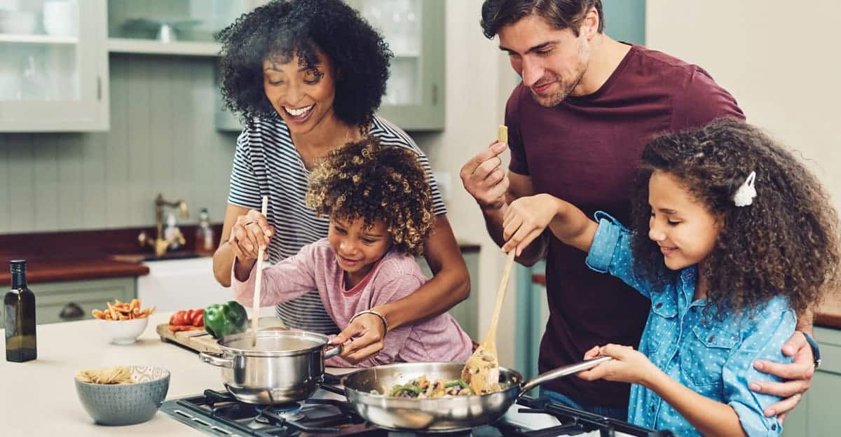 family with young kids cooking together