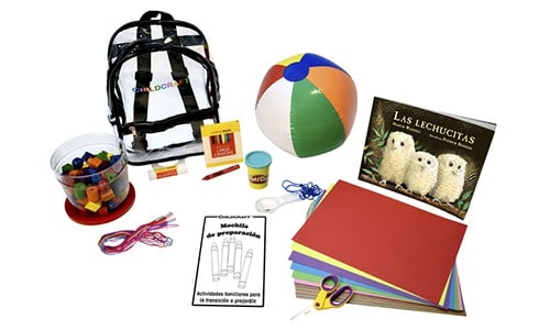 collection of materials including backpack, beach ball, construction paper, book, and basic school supplies