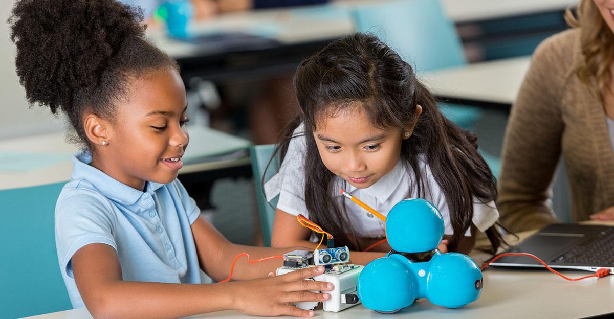 elementary students building a robot in STEM classroom