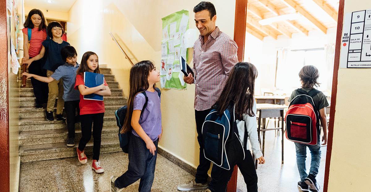 teacher respectfully welcoming students as they enter classroom