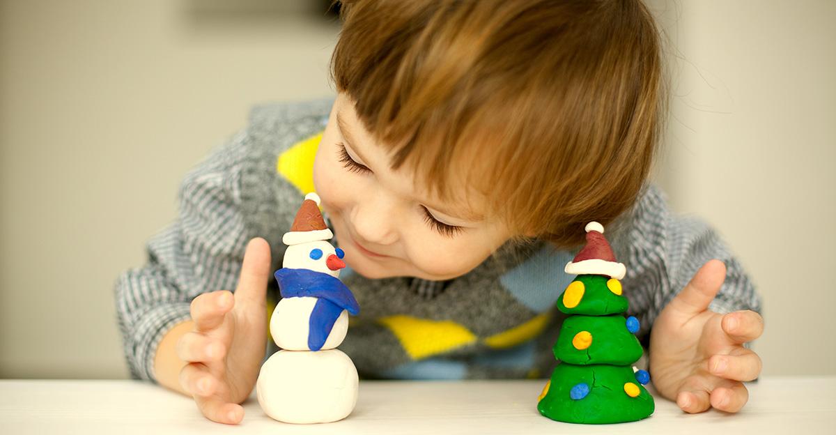 young student making holiday snowman and christmas tree crafts from modeling dough