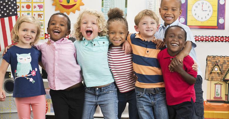 smiling students with arms around each other in the classroom