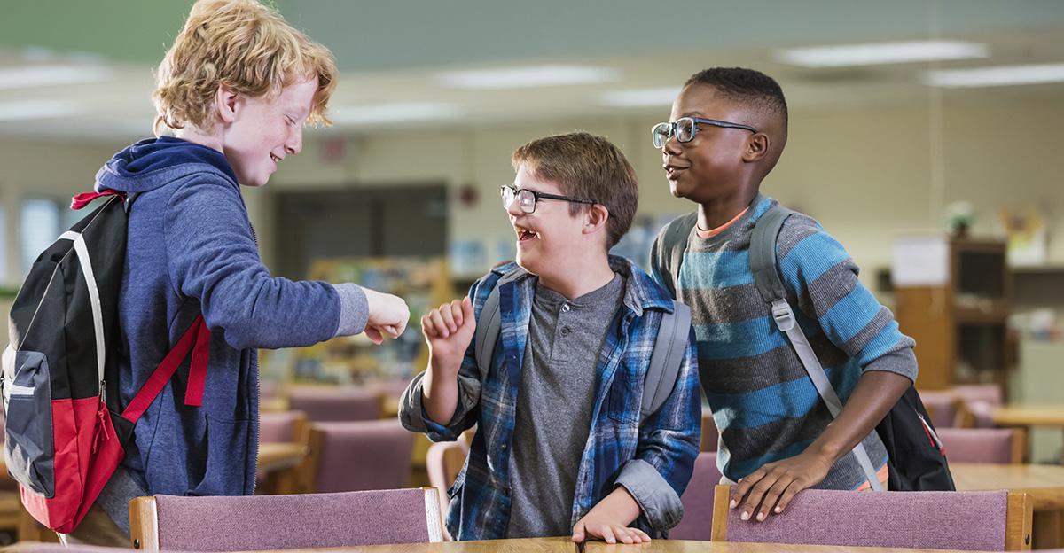 boy with down syndrome having fun with friends in inclusive classroom setting