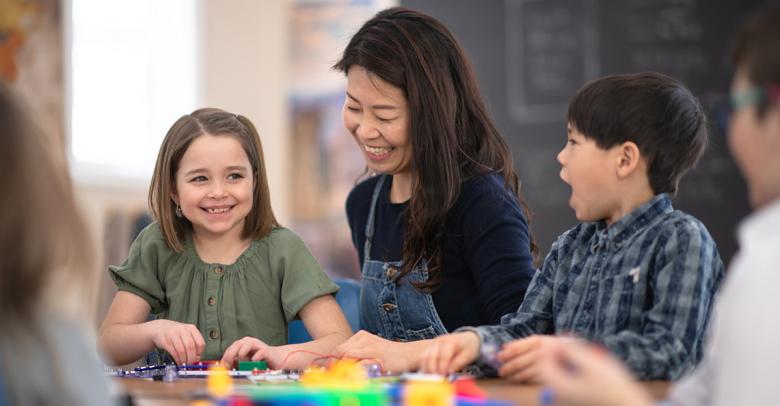 teacher working with small group of smiling students