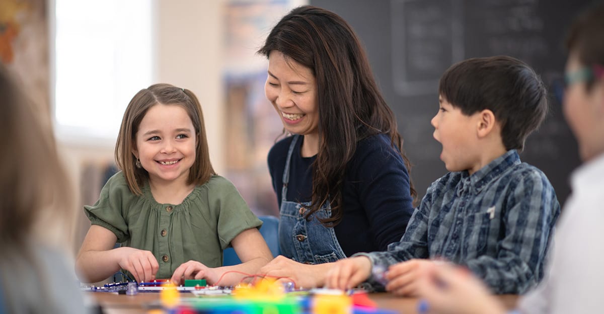 teacher working with small group of smiling students
