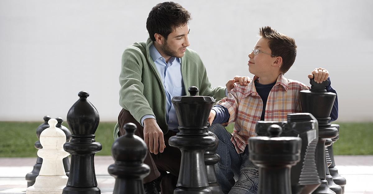 father and son playing a giant game of chess