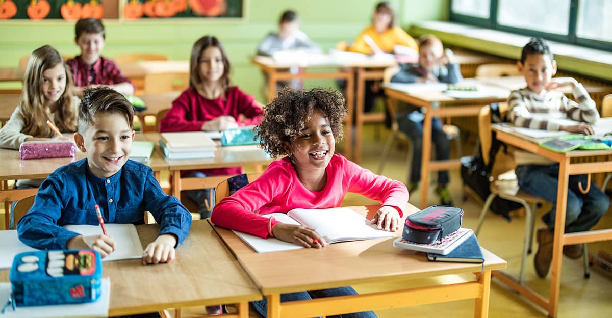 group of happy students in classroom learning environment