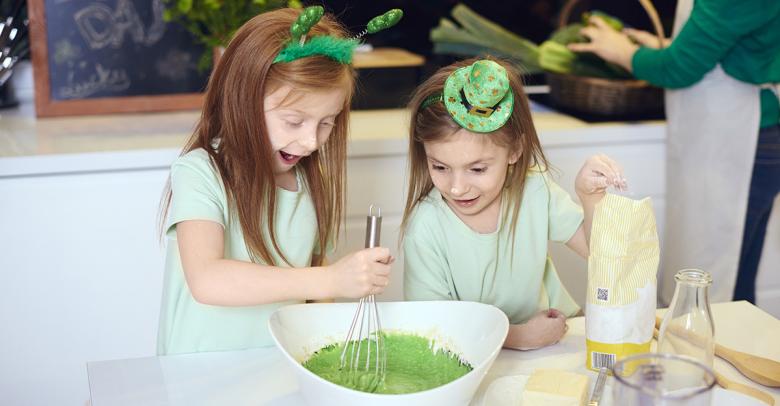 young girls mixing frosting for st. patrick's day cupcakes