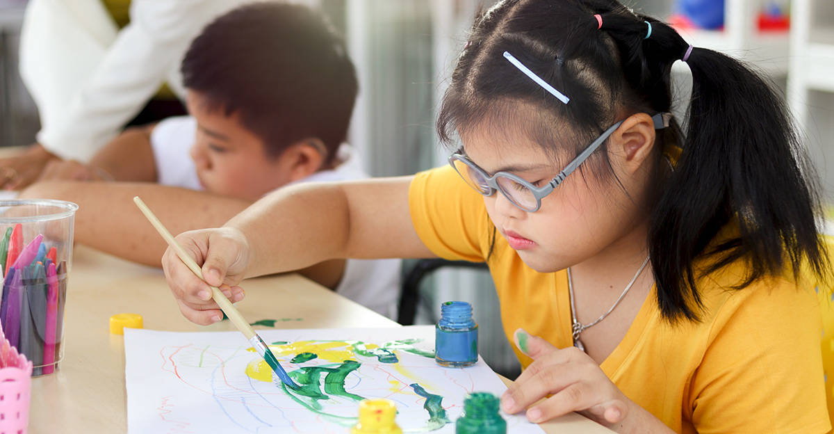 a student with special needs painting in an adaptive art class