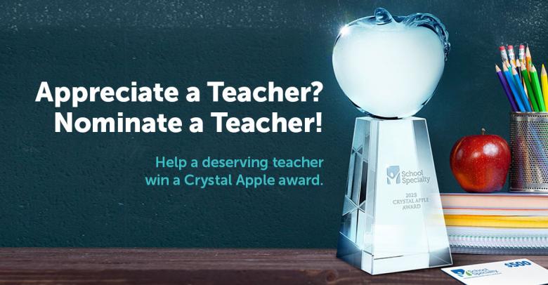 crystal apple award trophy next to classroom supplies and an appl