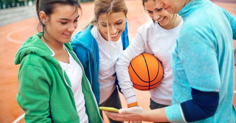physical education teacher using mobile technology to teach basketball