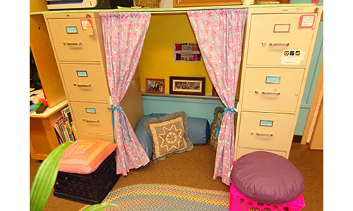 reading nook with pillows and curtains set between two filing cabinets