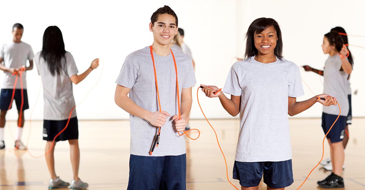 students with jump ropes in high school gym class