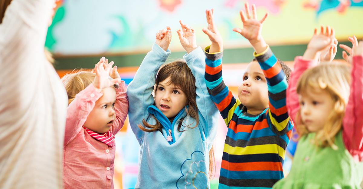 early childhood students raising their hands during physical activity
