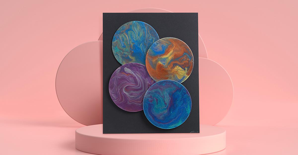 4 paint poured planets art project on pink pedestal and background