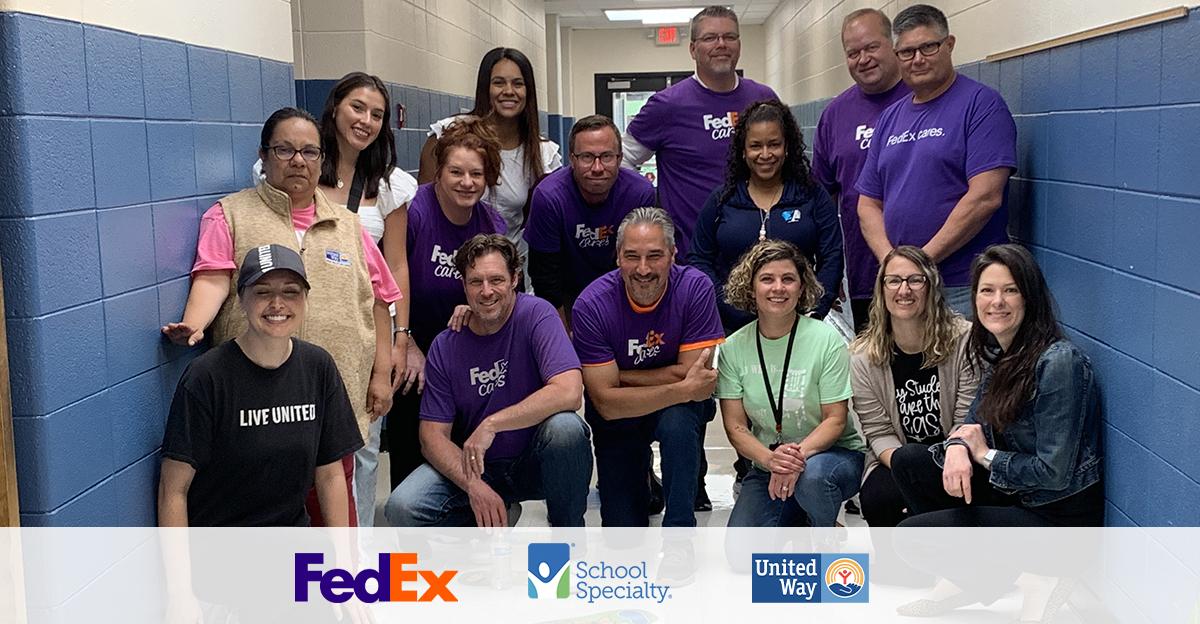 volunteers from fedex, school specialty, and the united way pose for a group picture after installing sensory pathways in an elementary school