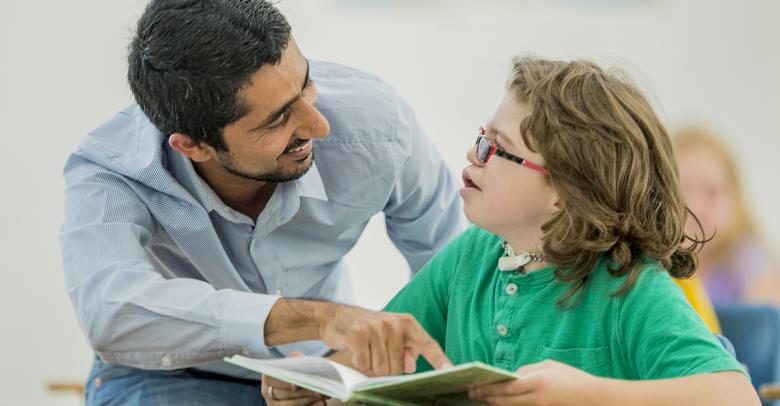 teacher helping a student with special needs learning to read