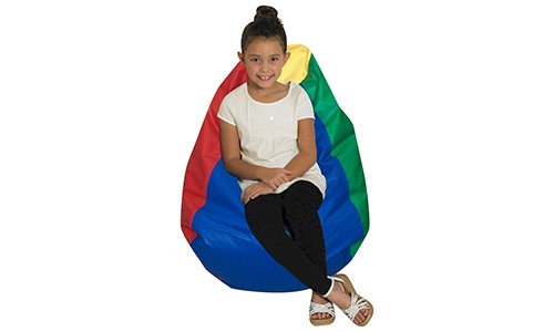 young child sitting on rainbow colored soft beanbag chair, looking at camera