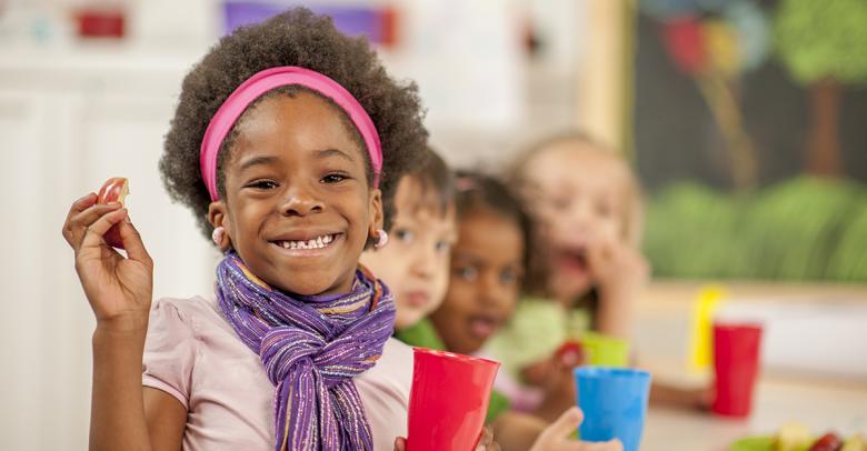 young students eating apples in the classroom