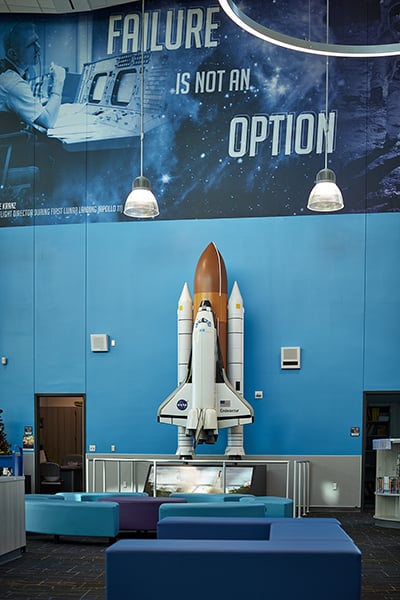 space shuttle replica in a school library with a graphic over it that says failure is not an option