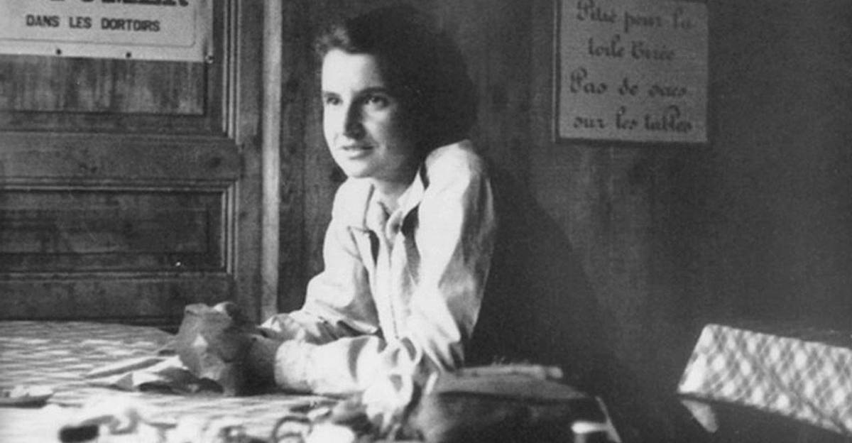 black and white grainy image of scientist rosalind franklin in paris, sitting at a table