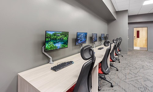side wall with gaming chairs and gaming computer monitors