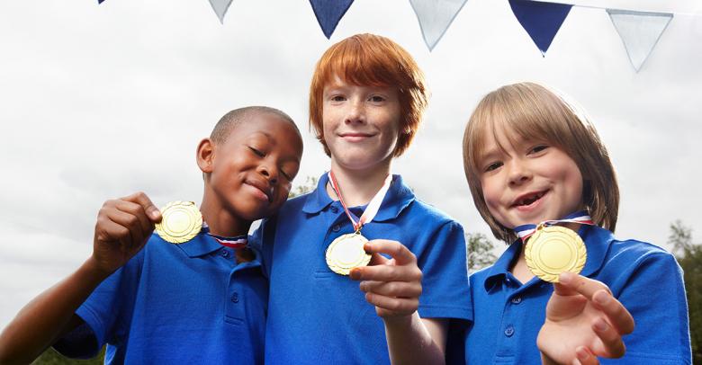 three students showing their medals from a mini-olympics competition