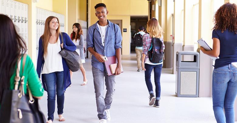 group of high school students walking in a school hallway