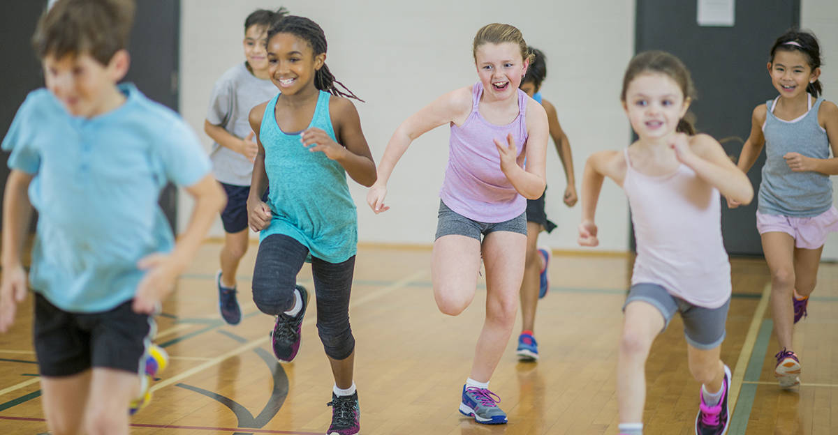 students smiling while running in pe class