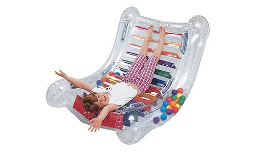 child laying upside down on an inflatable rocking toy