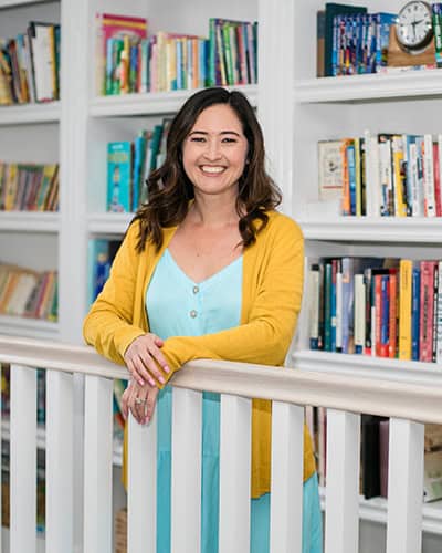 childrens' book author shannon olsen standing in front of a shelves of books