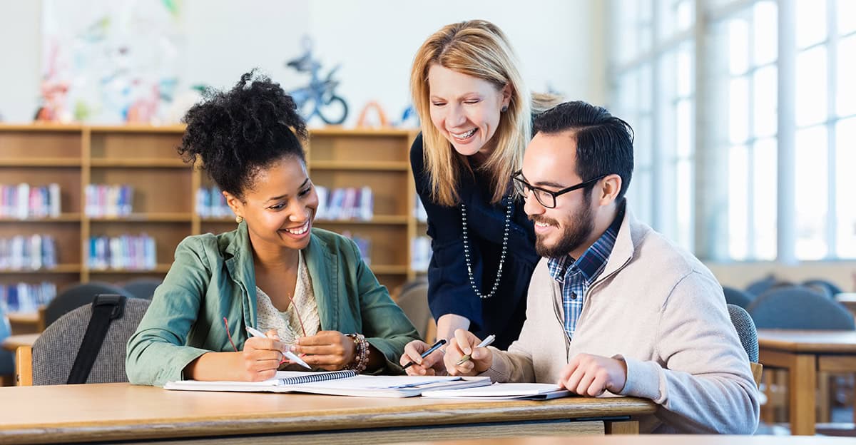 group of teachers in a library working on school calendar