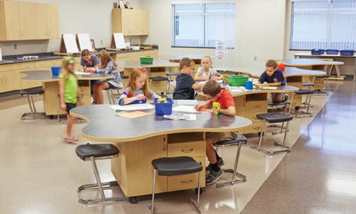 students doing work at a table in a school steam classroom