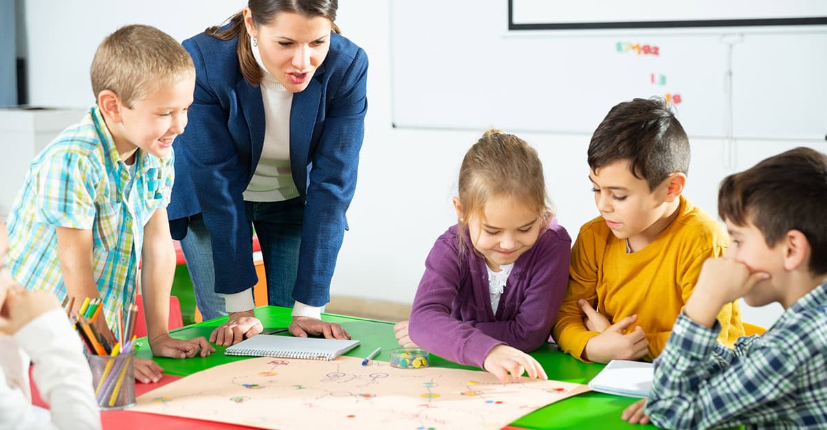 teacher and students playing a table game