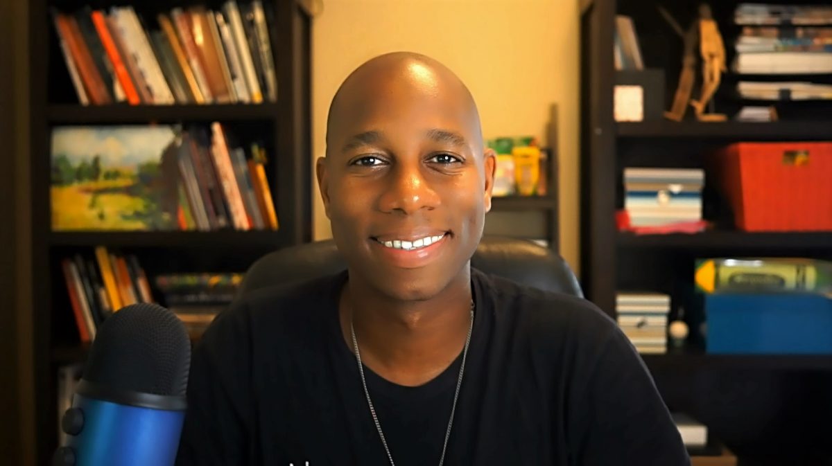 Headshot photo of James Wells in front of a bookcase.