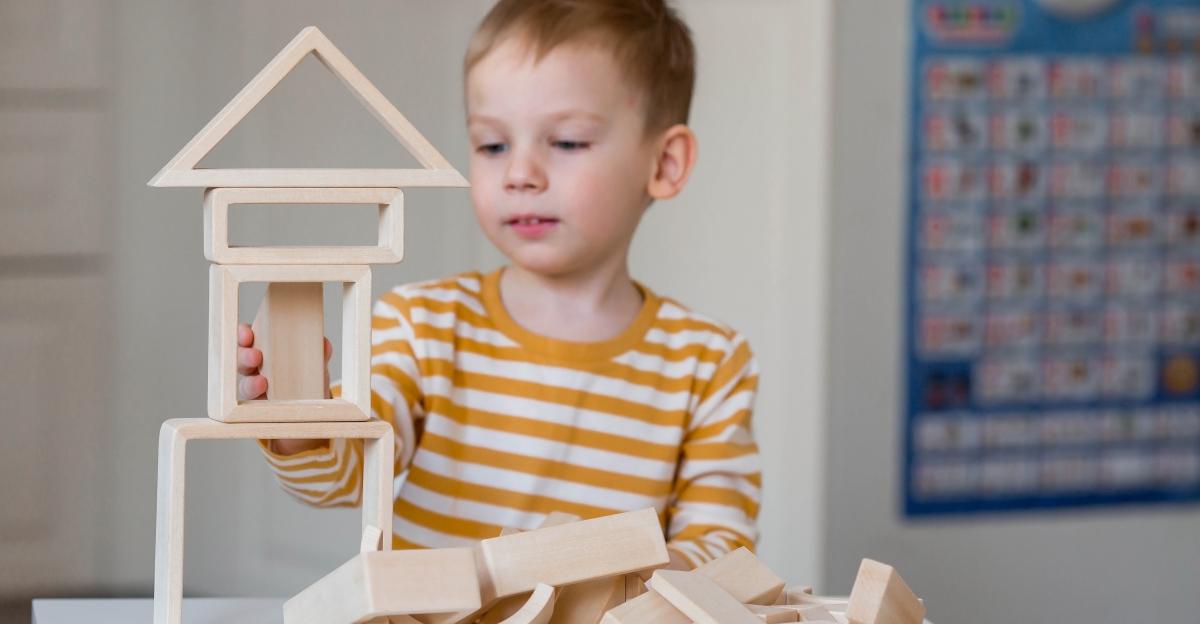 A little boy of 3 years old is playing a developing logistics constructor. Children's wooden toys. Montessori for child development.